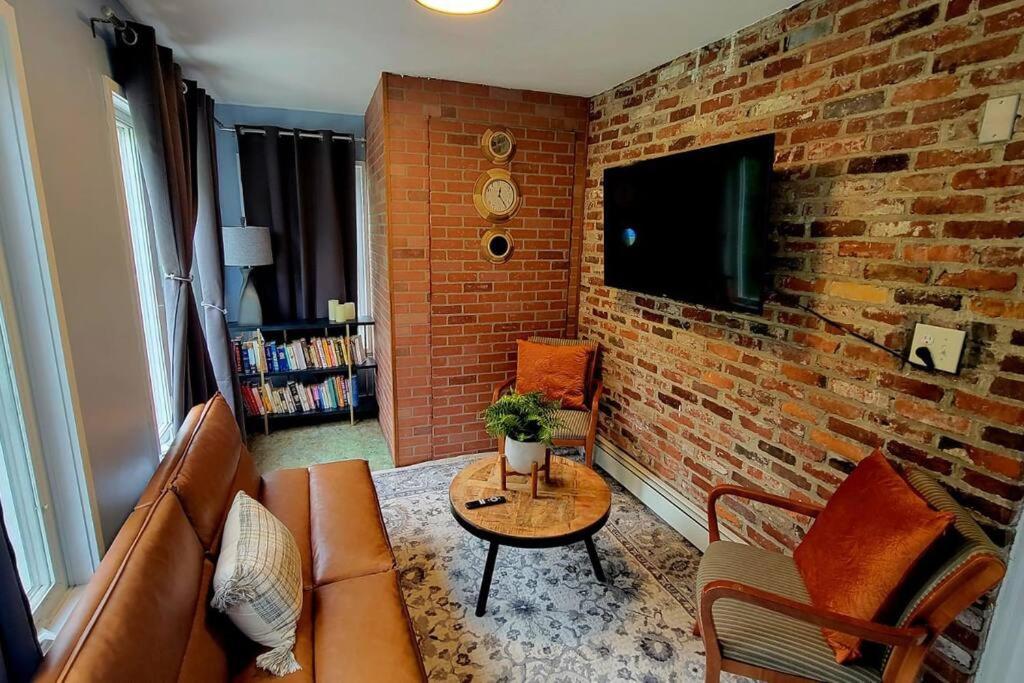 波士顿Unique & Peaceful Boston Home( Free Parking)的带沙发和砖墙的客厅