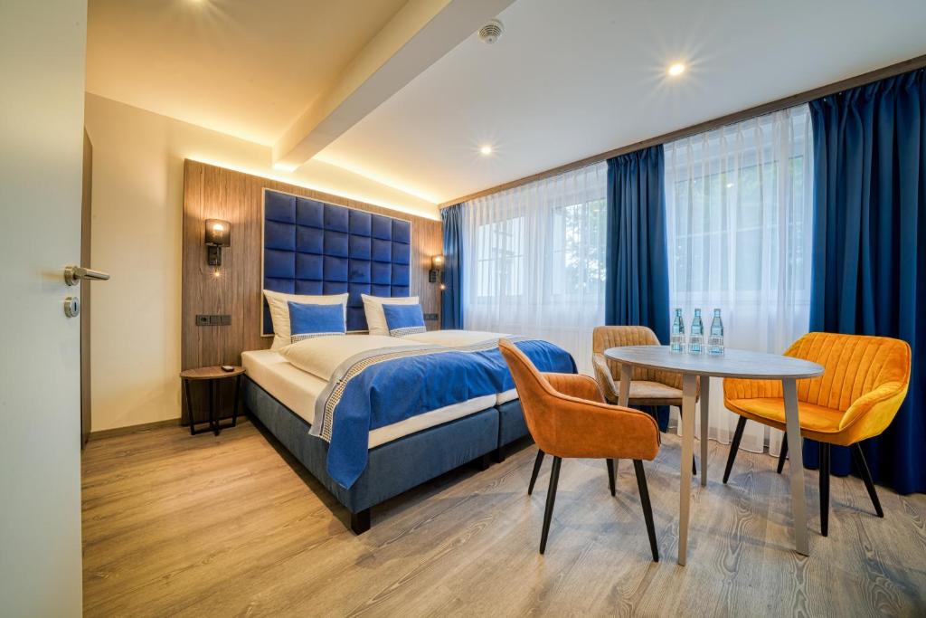 施塔德Zentrum Hotel Stade的酒店客房带一张床、一张桌子和椅子