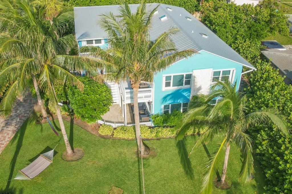 皮尔斯堡Hutchinson Island Beach House - Sleeps 32 - 8 BD的棕榈树蓝色房子的空中景色
