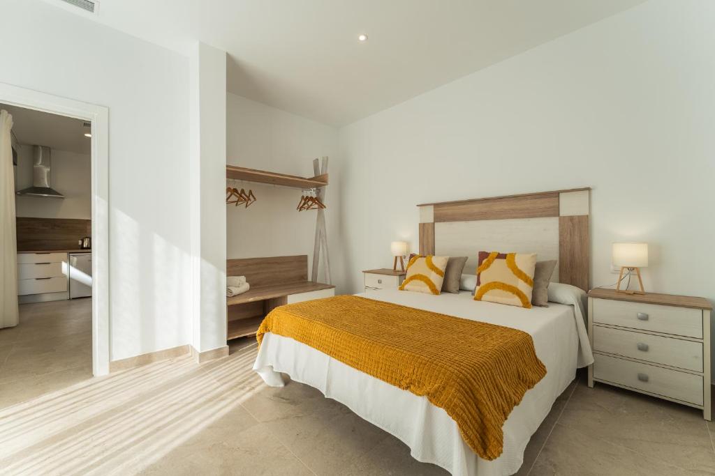 梅里达CMDreams Platinium- Apartamentos turísticos en el centro de Mérida的白色卧室配有黄色枕头的床
