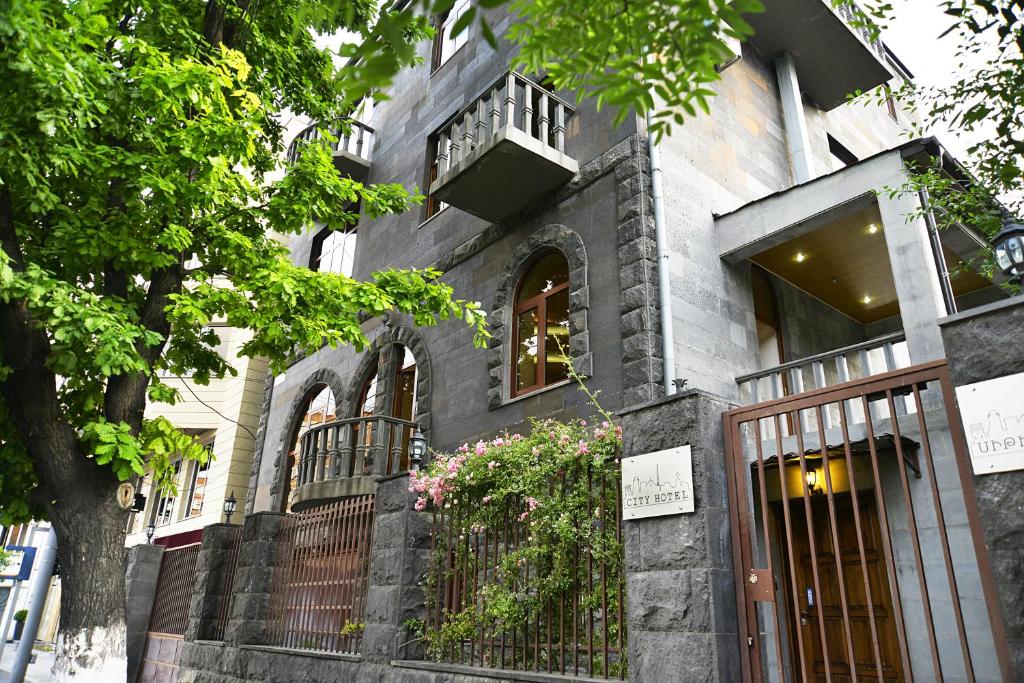 埃里温Saryan Hotel Yerevan的一座带铁门和阳台的建筑