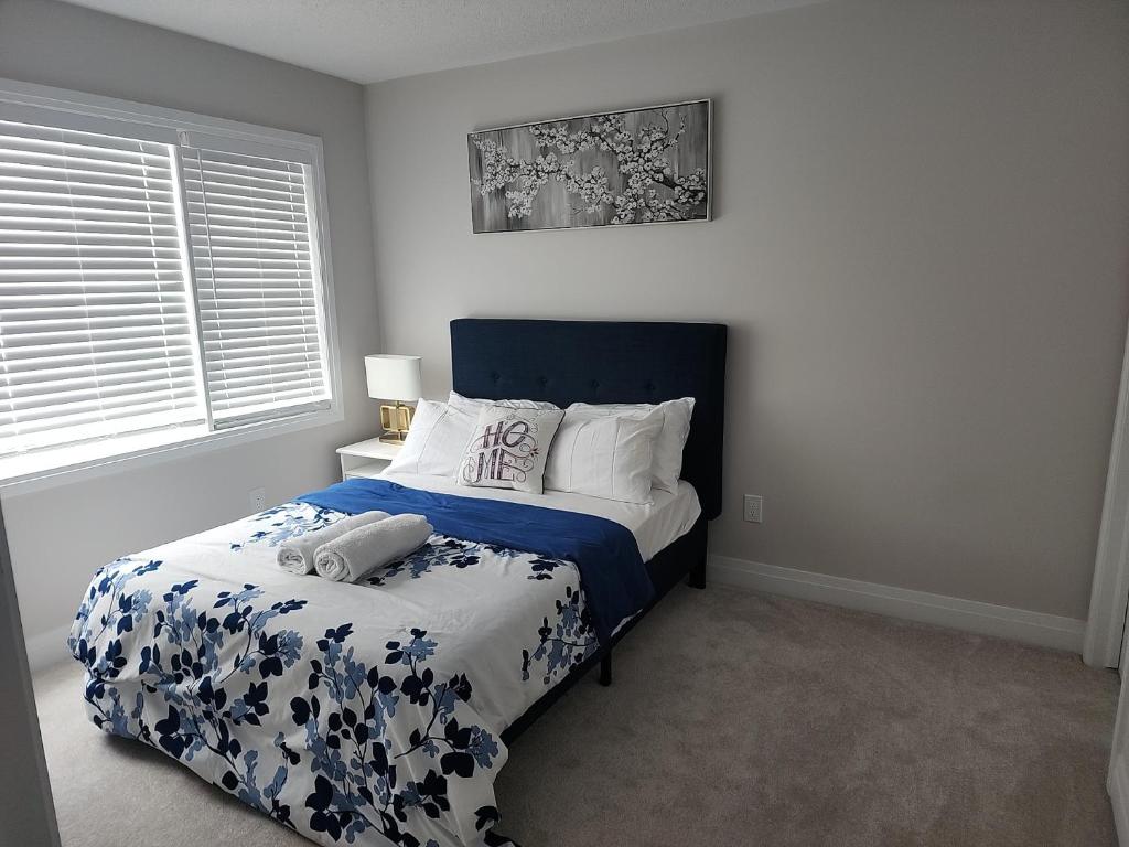 渥太华Dorothy's Place的一间卧室配有一张带蓝色和白色棉被的床