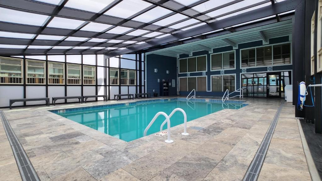 斩魔山马头城海滨华美达广场酒店的一座带玻璃天花板的大型建筑中的游泳池