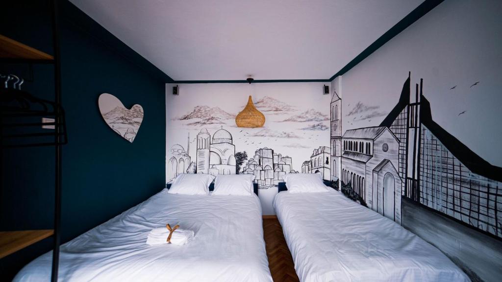 普里什蒂纳Prishtina In & Out的卧室配有两张床,墙上挂着画