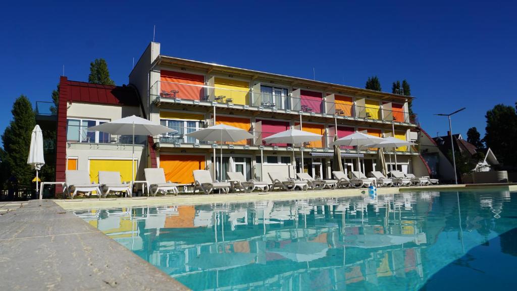希欧福克Colors Holiday Hotel的酒店设有带椅子和遮阳伞的游泳池