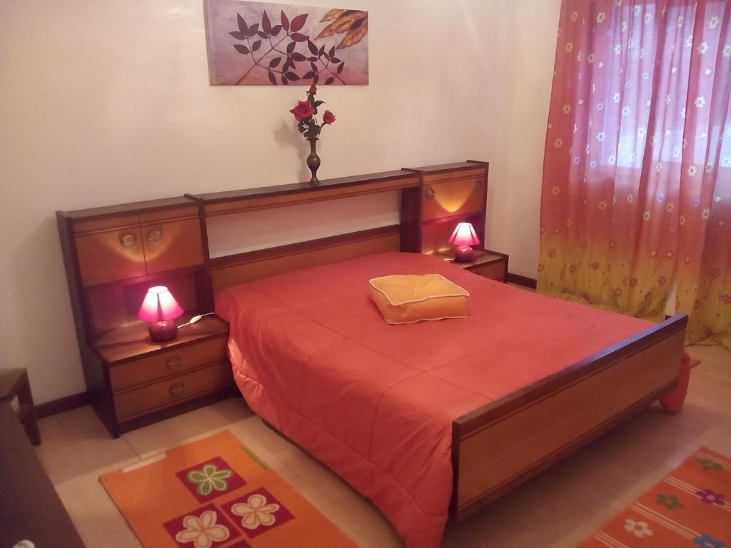 厄米森德Apartamento Aracelli的一间卧室配有一张带红色床单的床和两盏灯。