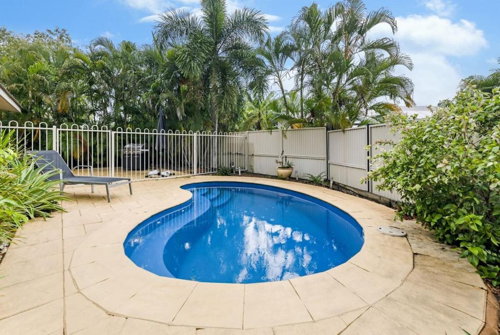 ParapAh Mat Bungalow - Tropical Darwin Stay with Pool的一个带围栏和树木的庭院内的游泳池