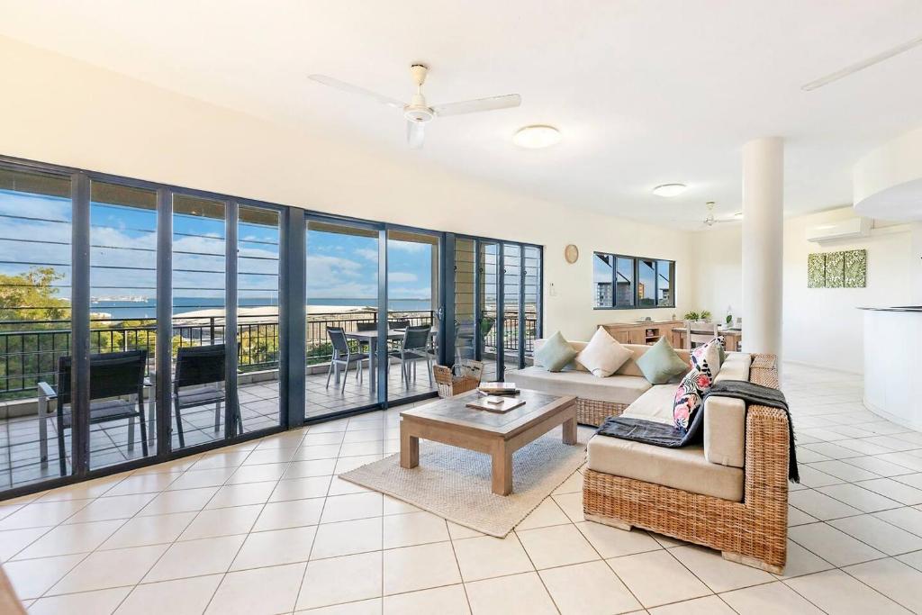 达尔文Oceanview Tropical - A Top End Poolside Oasis的客厅配有沙发和桌子
