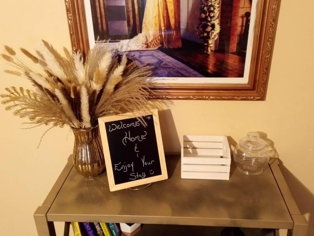 KathleenCountry Cottage的一张桌子,上面有黑板标志,桌子上有花瓶