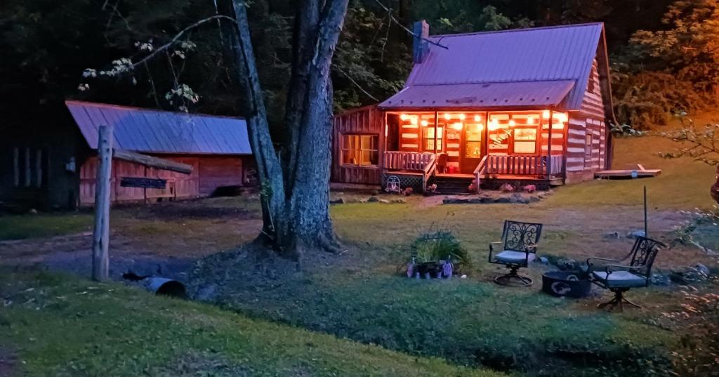 Rural RetreatThe Little Cabin on Huckleberry的夜间小木屋,灯光照亮
