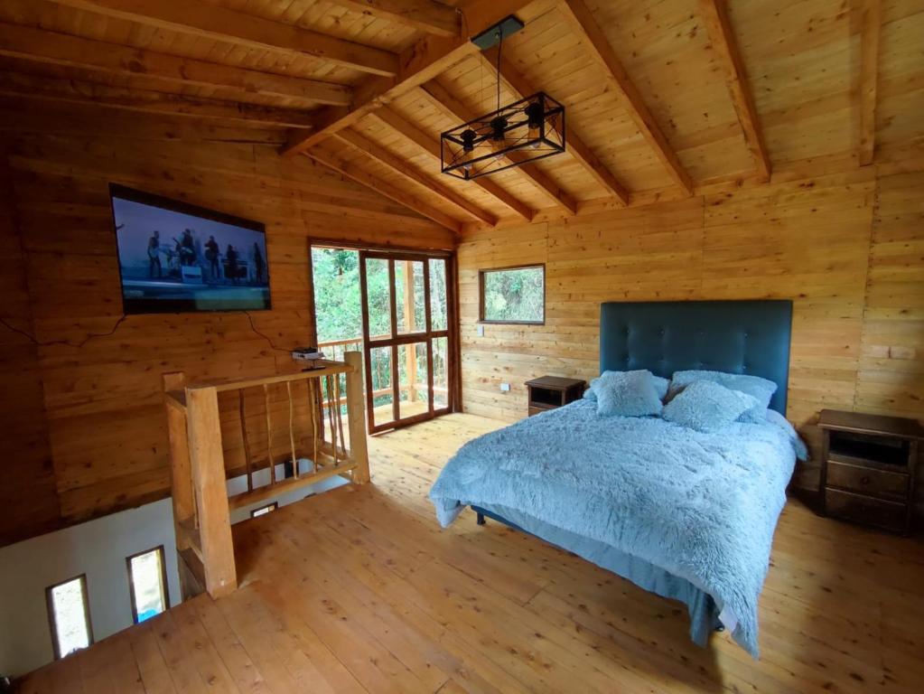 里奥内格罗cabaña paniym的小木屋内一间卧室,配有一张床