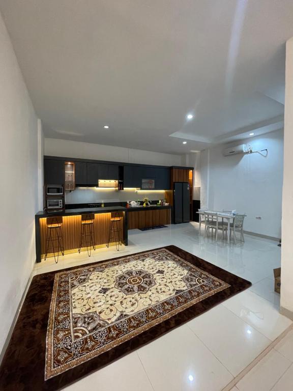 北干巴鲁Bagus house的客厅和厨房,地板上铺有地毯