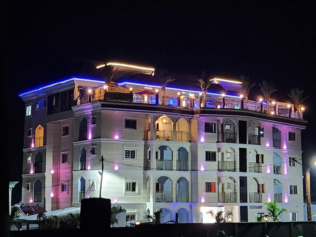 BueaRovie Estates的一座白色的大建筑,上面有紫色的灯