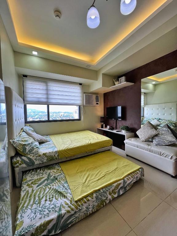 宿务Horizons 101 Condo in Cebu City的一间卧室设有两张床和窗户。