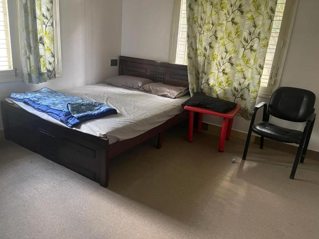 班加罗尔Jamesville-4BHK Villa, Wi-Fi, SmartTV - CityCentre的一间卧室配有一张带椅子和椅子的床