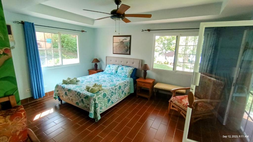 博卡奇卡Villas at Gone Fishing Panamá Resort的一间卧室配有一张床、一把椅子和窗户。