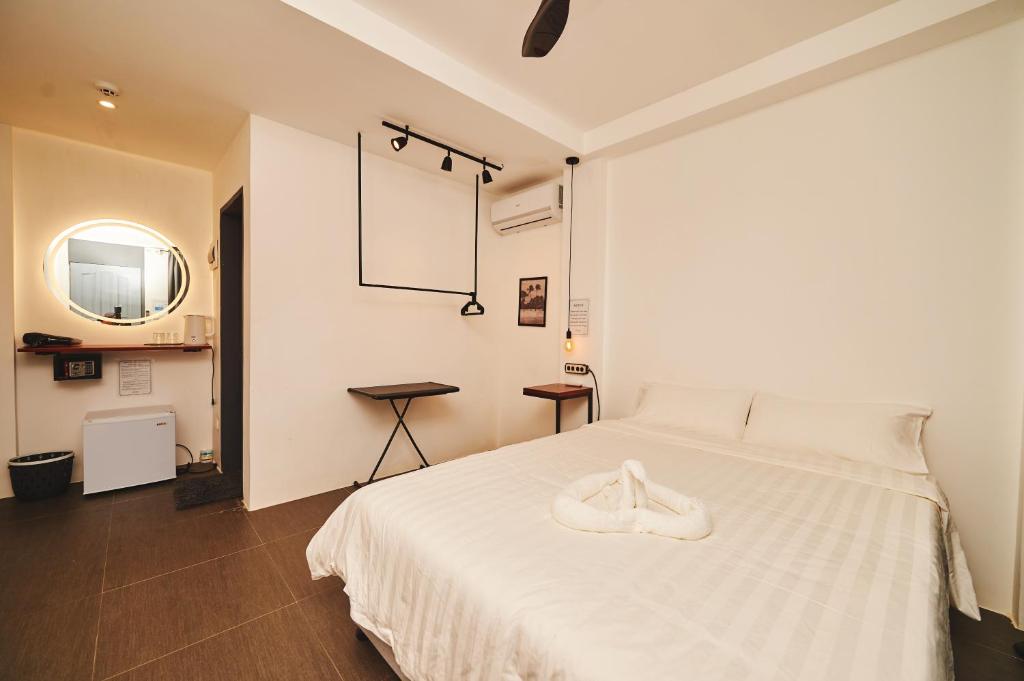 长滩岛Hotel Gray in Boracay的卧室配有一张白色的床,上面有一双鞋