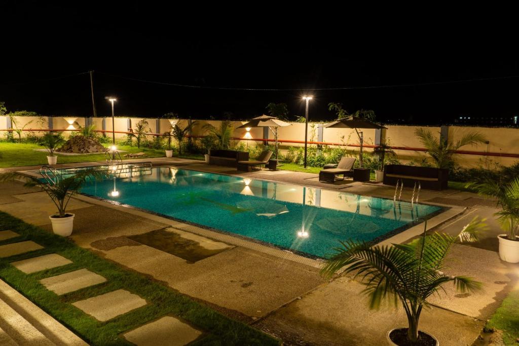 TinsukiaPalm Resorts的夜间在院子里的游泳池