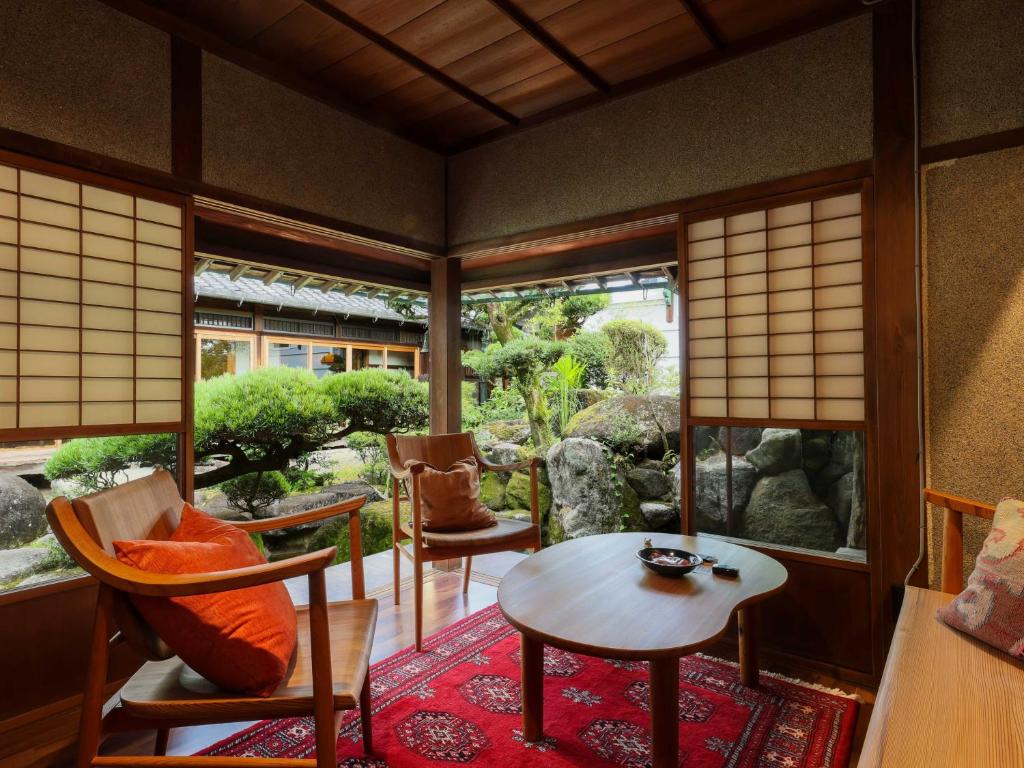 奈良NIPPONIA 田原本 マルト醤油的客房设有桌椅和窗户。