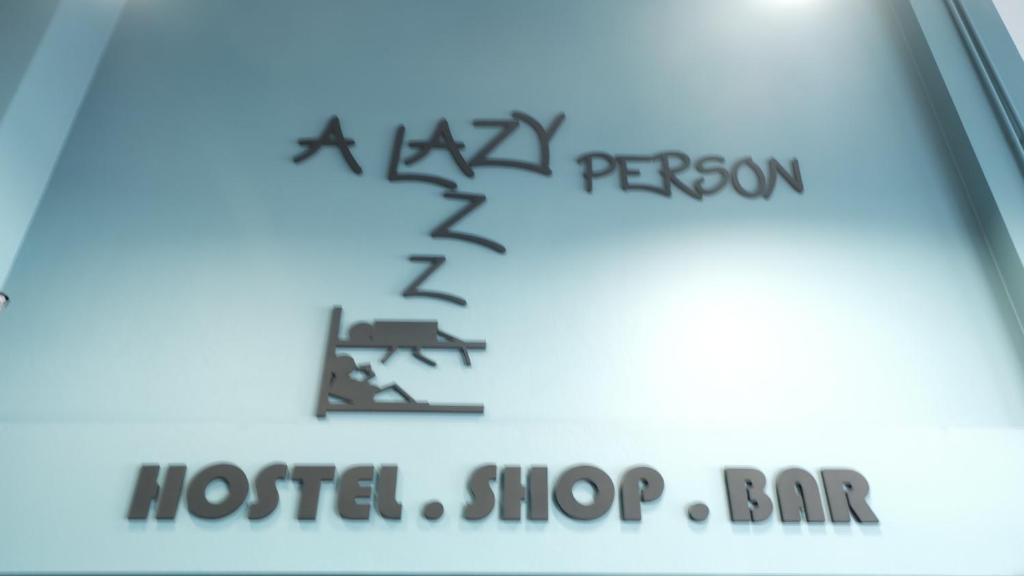 春蓬A lazy person hostel的一家酒店商店酒吧的标志贴近