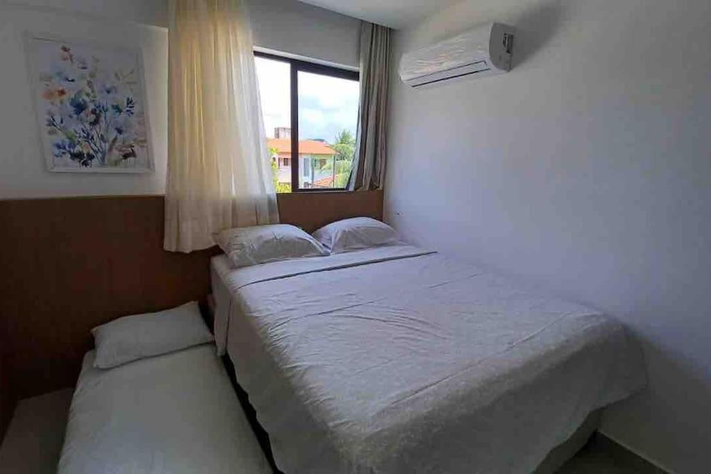 塔曼达雷Residencial Taormina - apartamento à beira-mar novinho!的一间小卧室,配有床和窗户