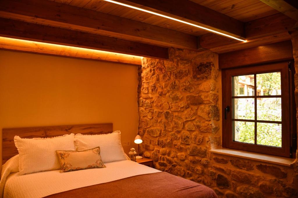 莱昂El Molino de Nocedo的一间卧室配有一张石墙床