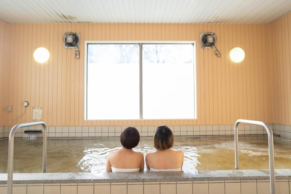 SukagawaKobohudonoyu的两个女人坐在带窗户的浴缸里