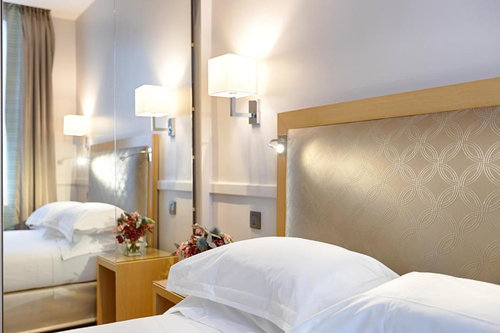 巴黎弗洛里德之星酒店的酒店客房,设有两张床和镜子