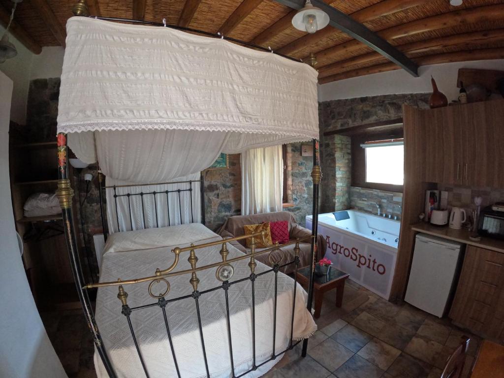 阿格罗斯AgroSpito Traditional Guest House的一间卧室配有一张天蓬床和一个浴缸