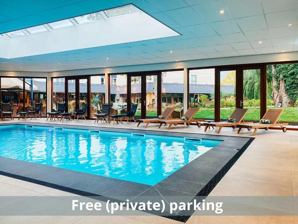 法尔肯堡格林莱恩酒店的一个带躺椅和大玻璃墙的酒店游泳池