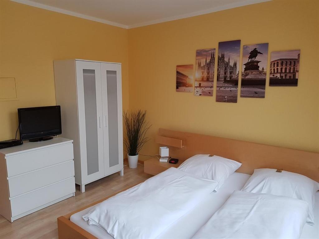 萨尔布吕肯瑙维瑟公寓式酒店的一间卧室配有两张床和一台平面电视