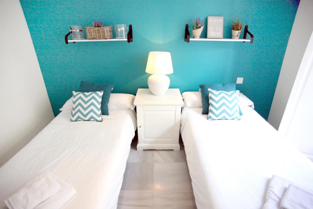 塞维利亚Sleepin Sevilla Catedral的一间卧室设有两张床和蓝色的墙壁