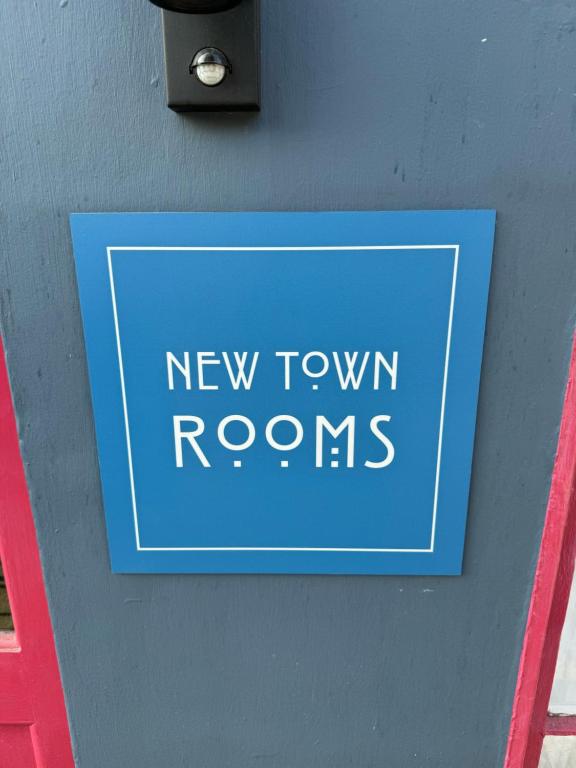 爱丁堡New Town Rooms的墙上的一个标牌,上面写着新排房