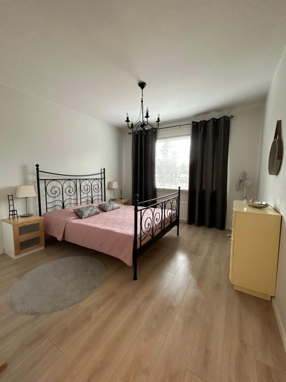 科特卡Apartments ”Enkeli”的一间卧室配有一张带粉色床单的床和一扇窗户。