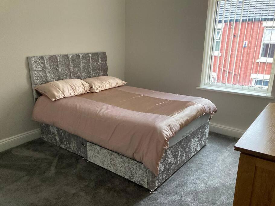 利物浦City and football的一间卧室配有一张带床头板的床和窗户
