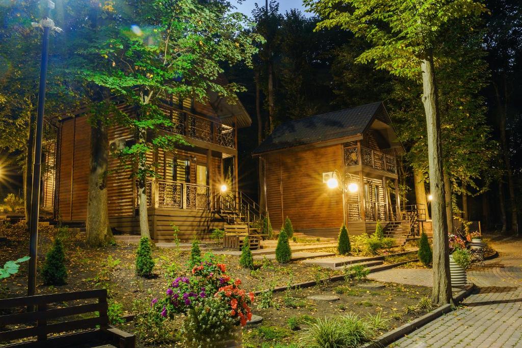 文尼察Готельно-ресторанний комплекс БОЖЕДАР的夜间花园中灯火通明的小木屋