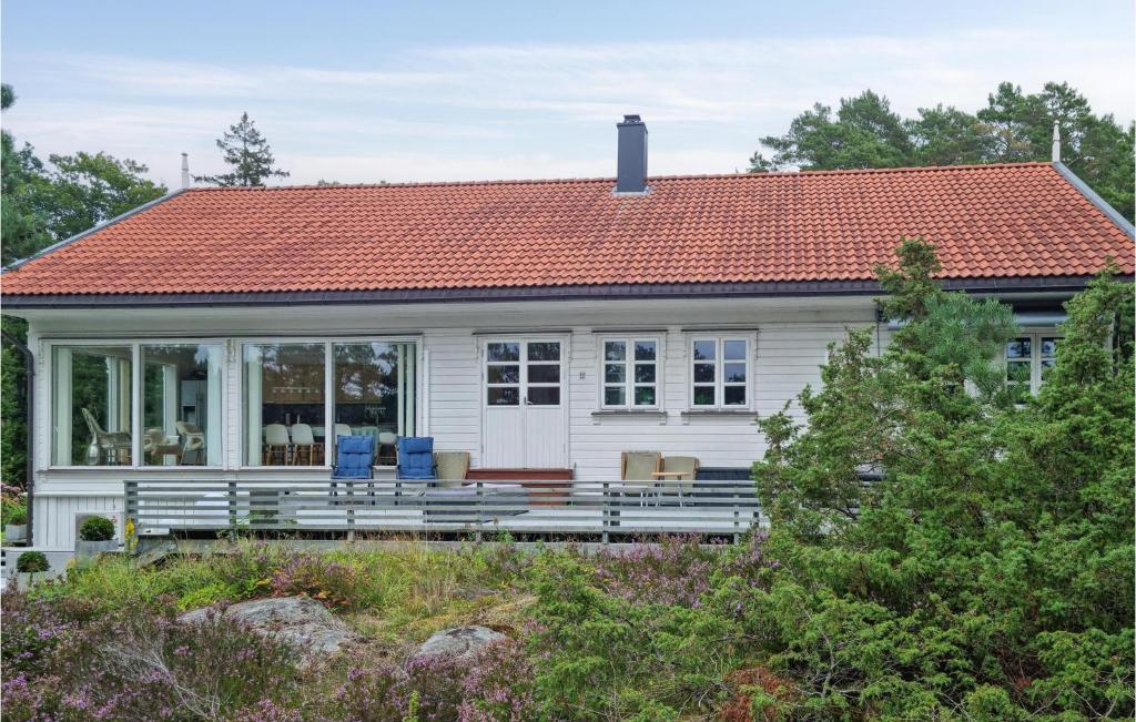 格里姆斯塔Cozy Home In Grimstad With House Sea View的一座白色的小房子,拥有橙色的屋顶