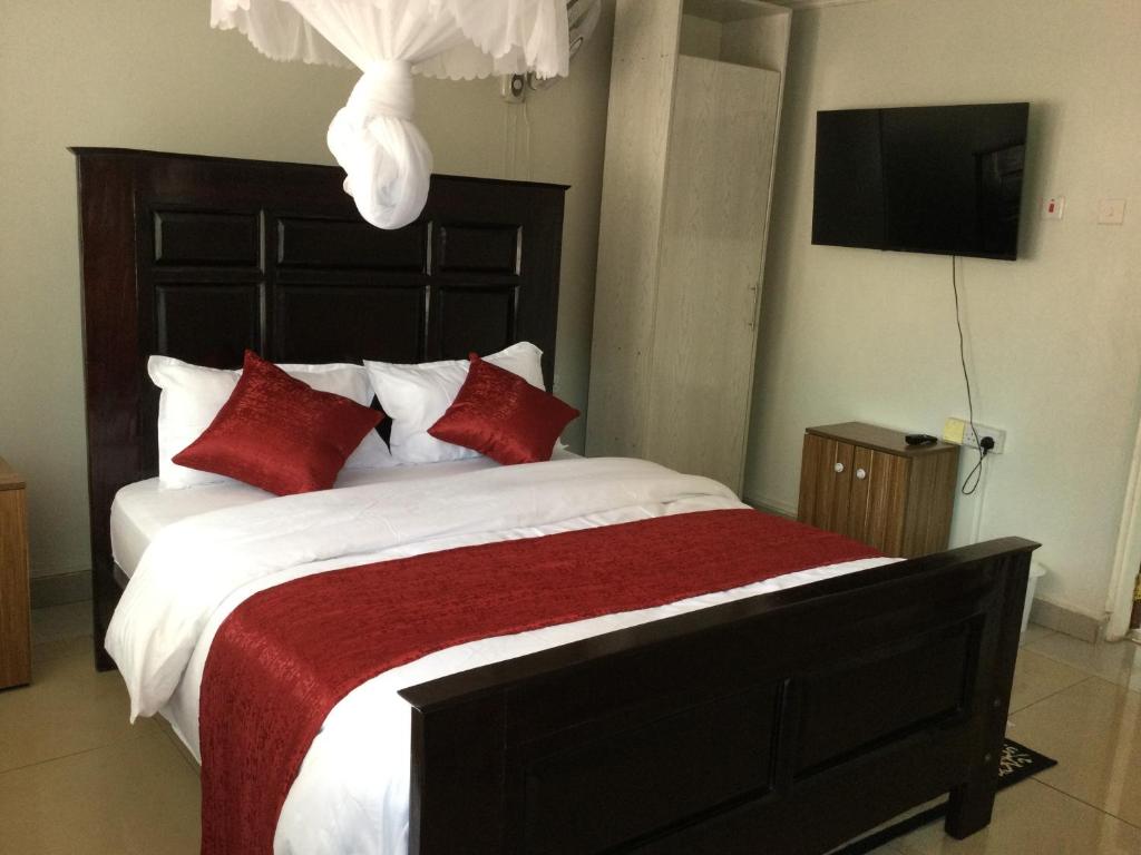 基苏木Milimani Comfort的一间卧室配有一张带红色枕头的大床