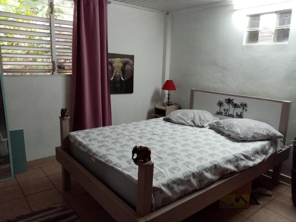 法兰西堡Nature的一间卧室,卧室里配有一张床,狗坐在床上