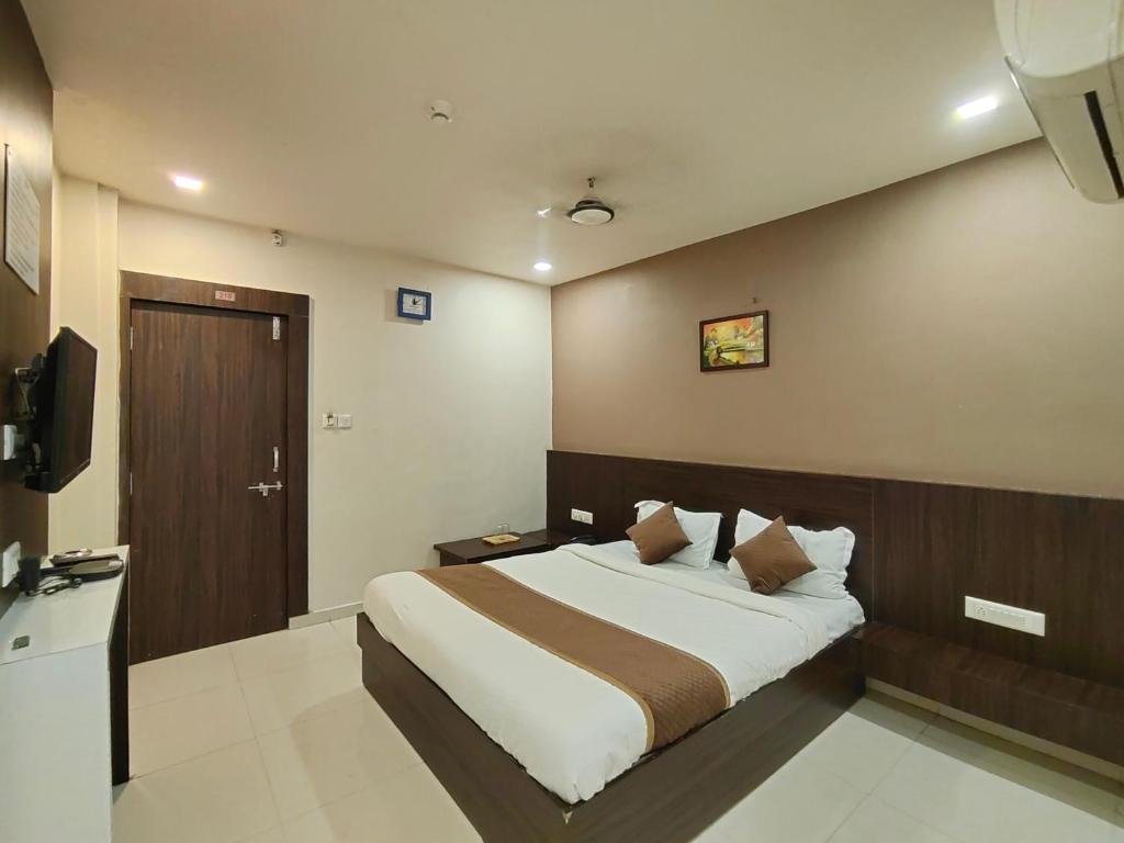 艾哈迈达巴德Hotel Palav Palace的一间卧室配有一张床和一台电视