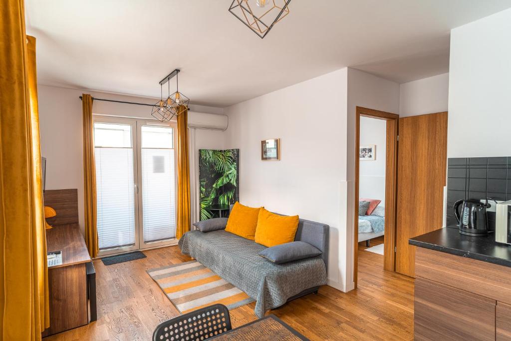 克拉科夫Apartament Chmielna Loft的客厅配有带橙色枕头的沙发