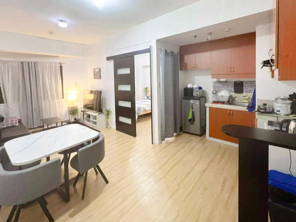 马尼拉One Bedroom condo Unit in Eastwood Libis . Fast free wifi /netflix的厨房以及带桌椅的起居室。