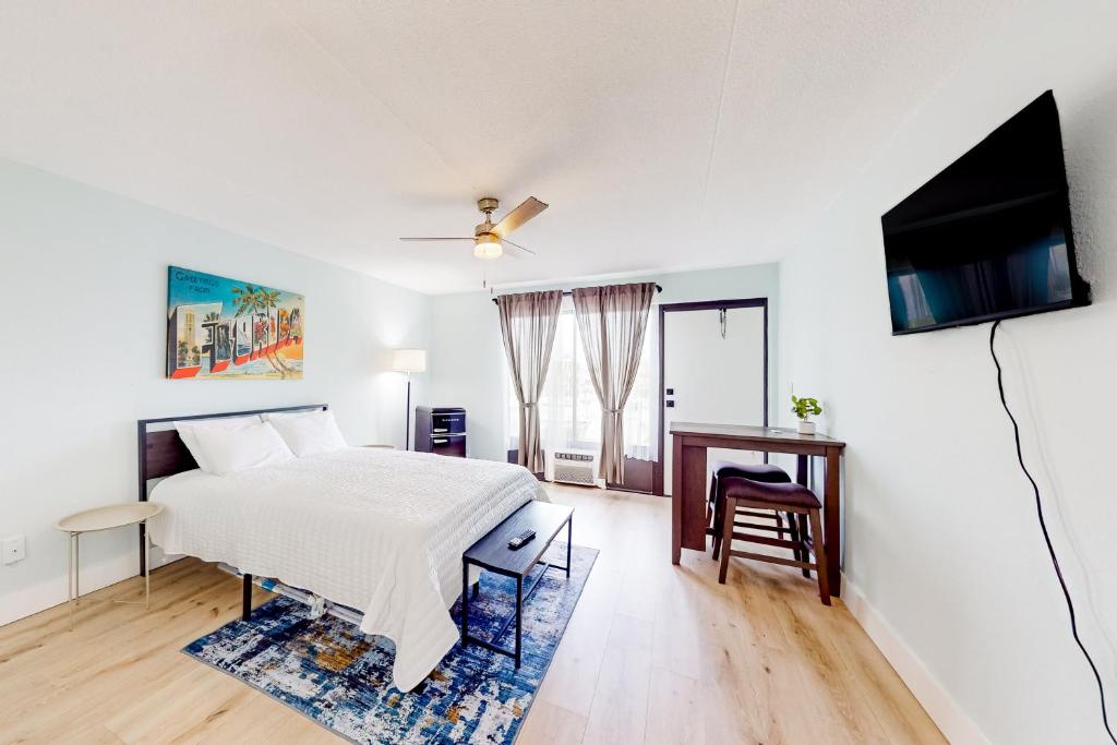 马可岛Capri 103的白色卧室配有床和平面电视