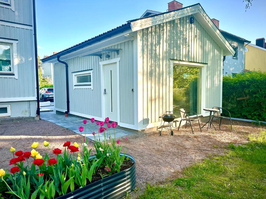 耶夫勒Park House Gävle - a modern renovated house in the park - 5A的小棚子,配有桌椅和鲜花