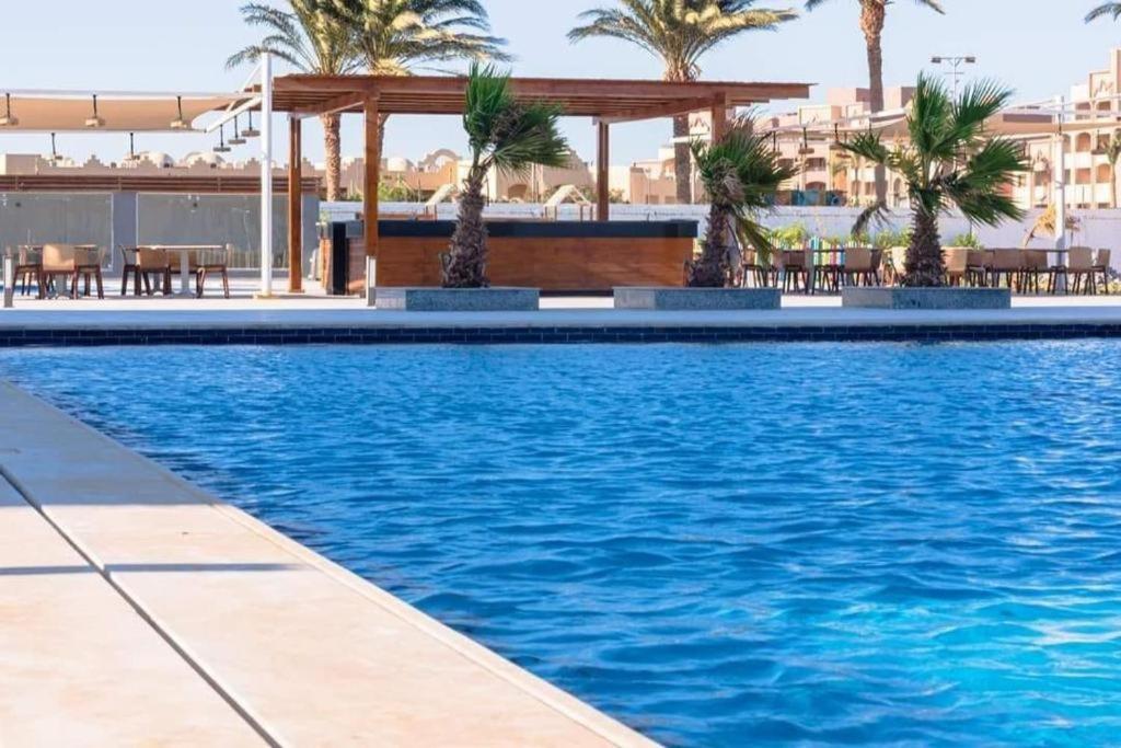 赫尔格达Scandic resort سكانديك ريزورت的一个带棕榈树和凉亭的游泳池