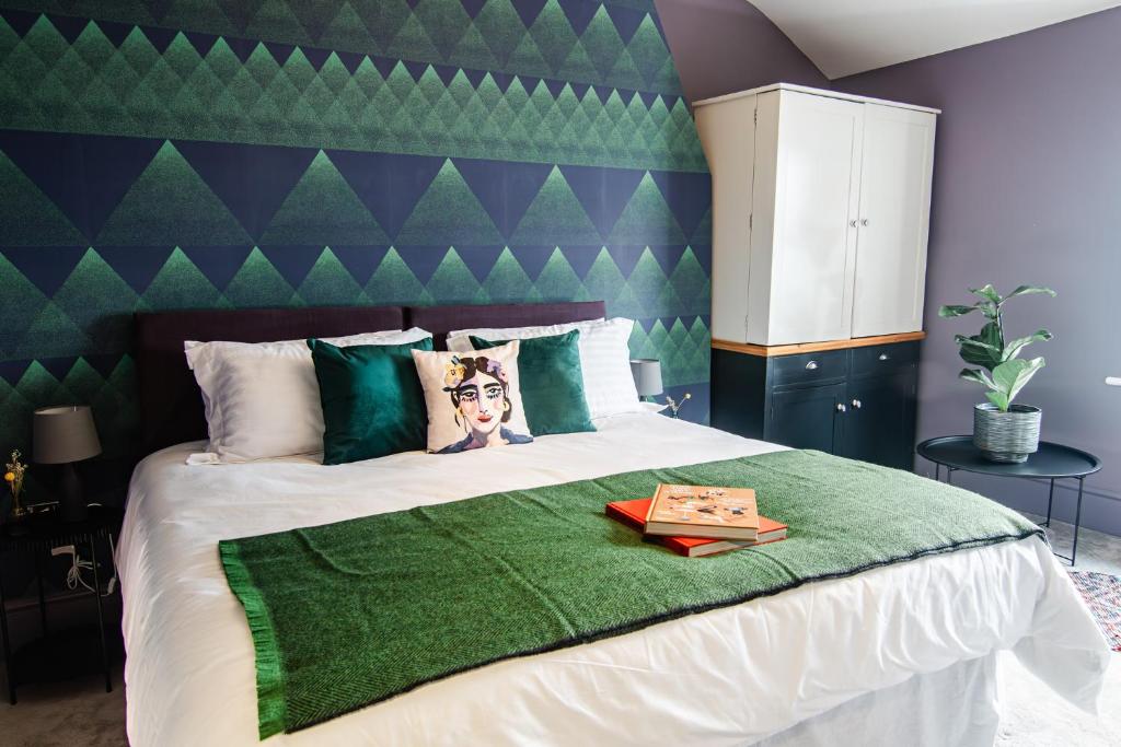 哈罗盖特The Marmot的一间卧室配有一张大床和绿色床头板