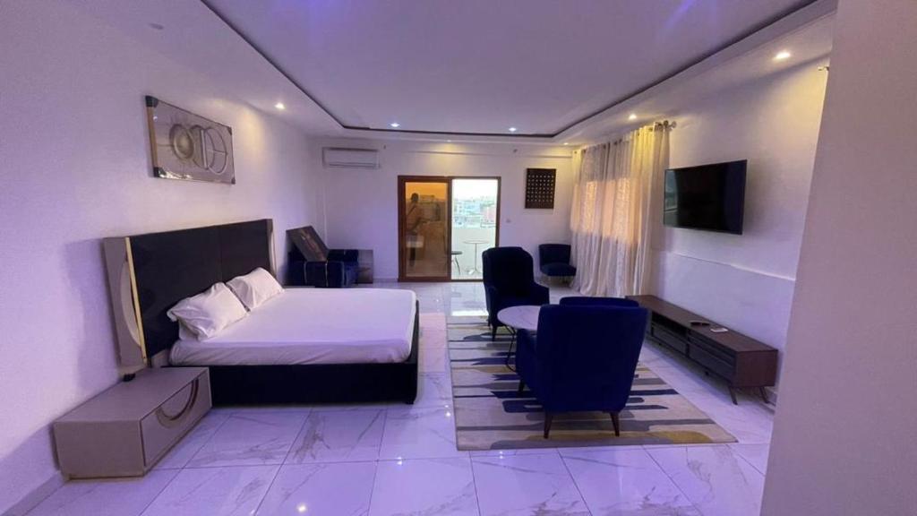 达喀尔BI HOTEL 2的酒店客房带一张床、一张桌子和椅子