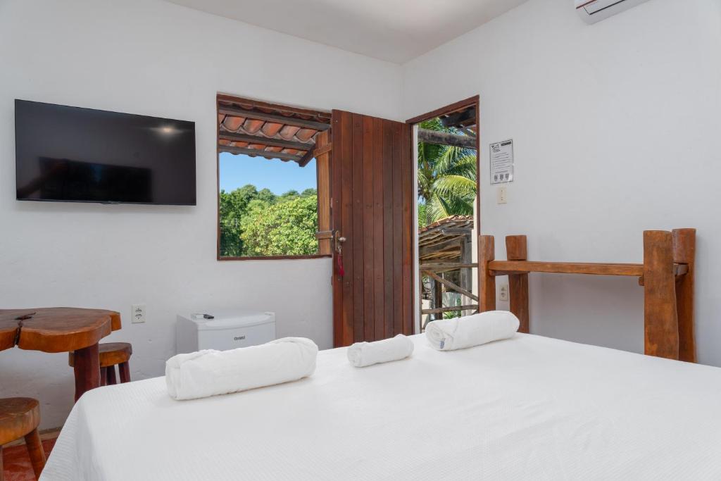 普拉亚弗朗西丝Pousada Trilha do Mar的一间卧室配有一张带白色床单的床和一扇窗户。