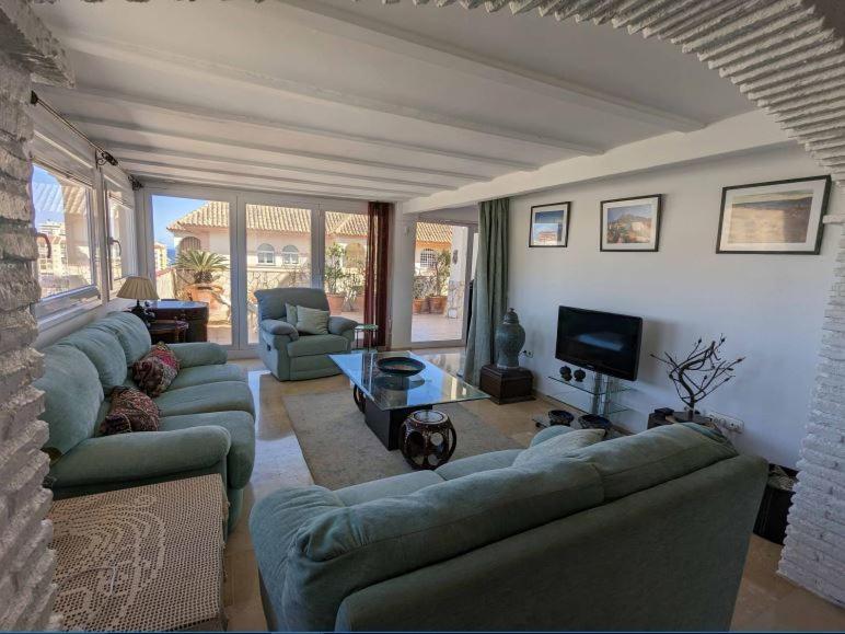 福恩吉罗拉Sea view penthouse的客厅配有蓝色的沙发和电视