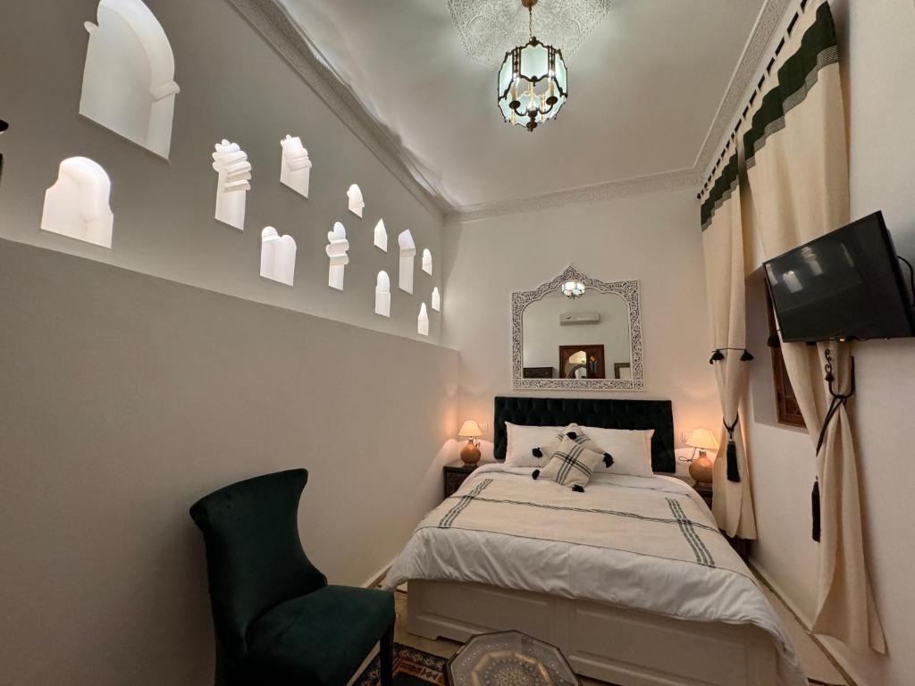 丹吉尔Riad Al-Qurtubi的一间卧室配有一张床、镜子和椅子